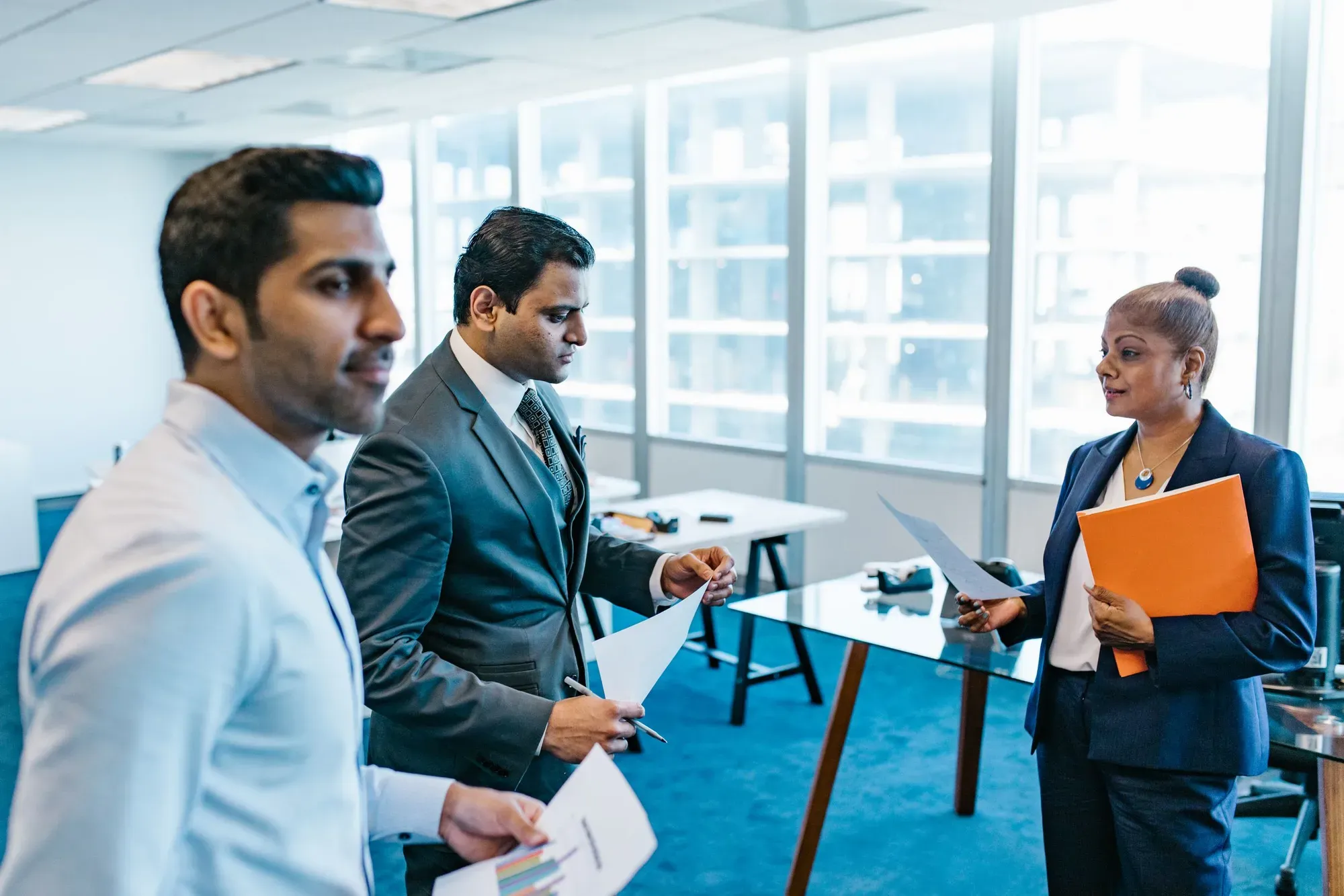 Consultants discussing documents in a modern office